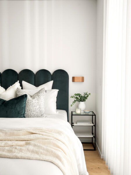 Lived-in luxury interior design 2025 featuring deep green and earthy tones, rich textures, bouclé furniture, velvet accents and sculptural lighting in a sophisticated modern living room.